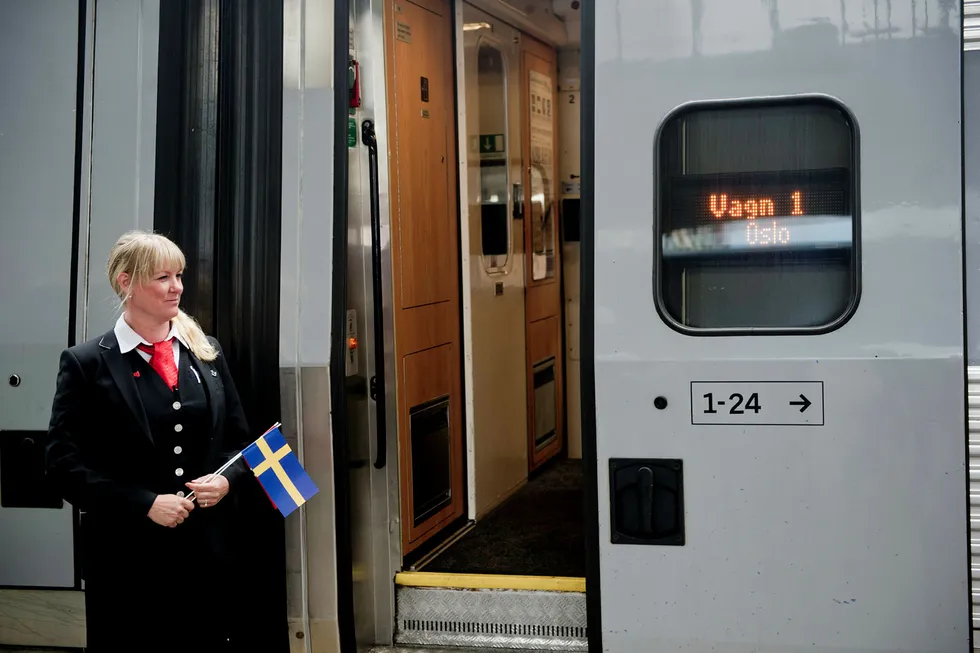 En konduktør foran toget som betjener hurtigtoglinjen mellom Stockholm og Oslo ved spor 19 på Oslo Sentralstasjon da linjen åpnet i 2015.