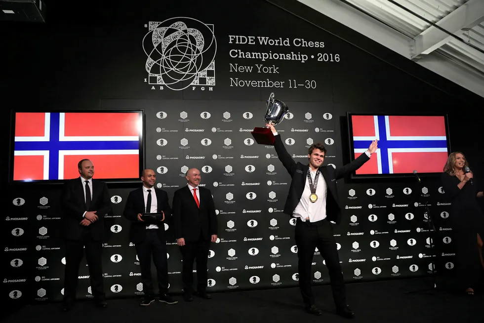 Magnus Carlsen kan endelig heve trofeet etter å ha beseiret russiske Sergej Karjakin. Foto: Mark Kauzlarich/Reuters/NTB Scanpix