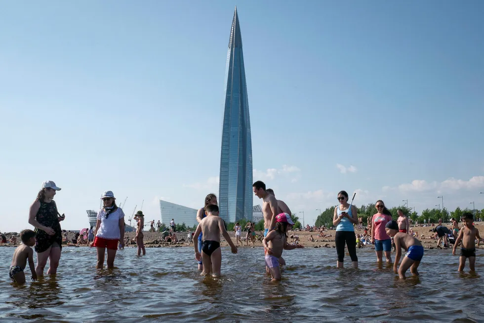 Running aground: people bathe on a beach in St Petersburg in Russia with Lakhta Centre, headquarters of Gazprom, in the background
