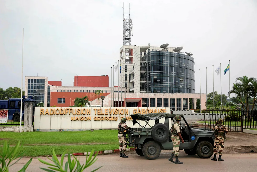 Drama: Gabonese soldiers stand in front of the headquarters of the national TV broadcaster in Libreville on 7 January after a group of soldiers (pictured inset) burst into the station and called on the public to 'rise up' as they sought to take power in Gabon while the country's ailing president was abroad