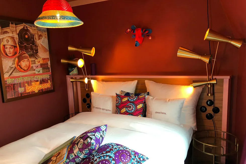 Bollywood-plakater på veggen, kombinert med afrikanskinspirerte puter og taklampee, samt lysbrytere og sengelamper akkurat som hjemme hos oldemor.