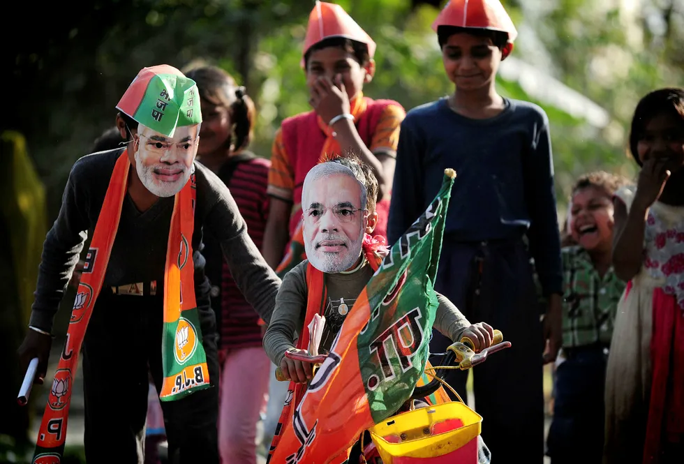 Indias statsminister Narendra Modi har skapt økonomisk vekst og tvunget frem reformer i økonomien. Her leker indiske barn med masker som viser ansiktet til Modi. Foto: Sanjay Kanojia/AFP/NTB scanpix