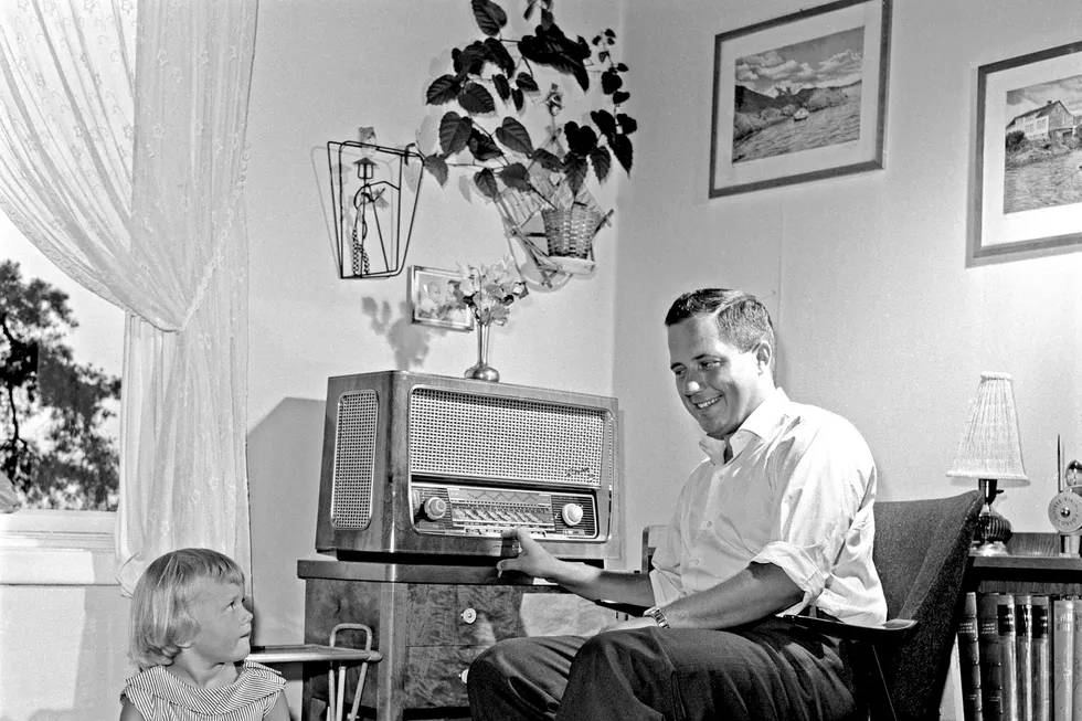 August 1959. Skuespiller og imitator Rolf Just Nilsen lytter på «Ønskekonserten» på radio i sin stue, sammen med lille Brita. Foto: Aage Storløkken/NTBScanpix Foto: Storløkken, Aage,/NTB scanpix