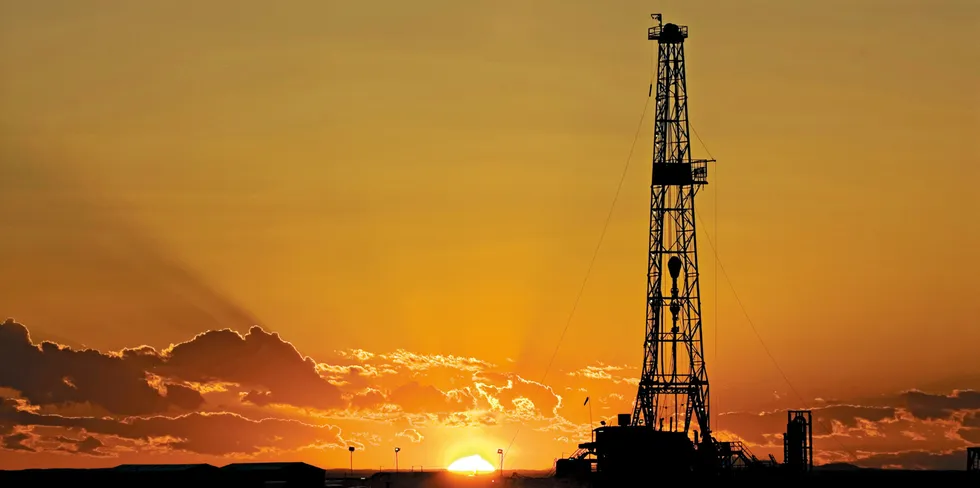 Sun sets behind a drill rig in in Artesia, New Mexico