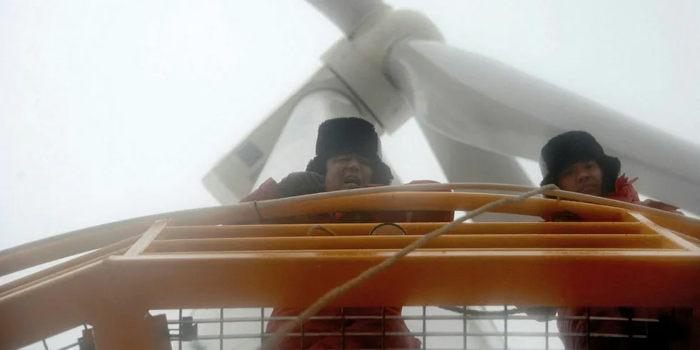 Engineers peer down during routine maintenance of a wind turbine at the Longyuan Rudong Intertidal Demonstration in Rudong, Jiangsu Province, China.
