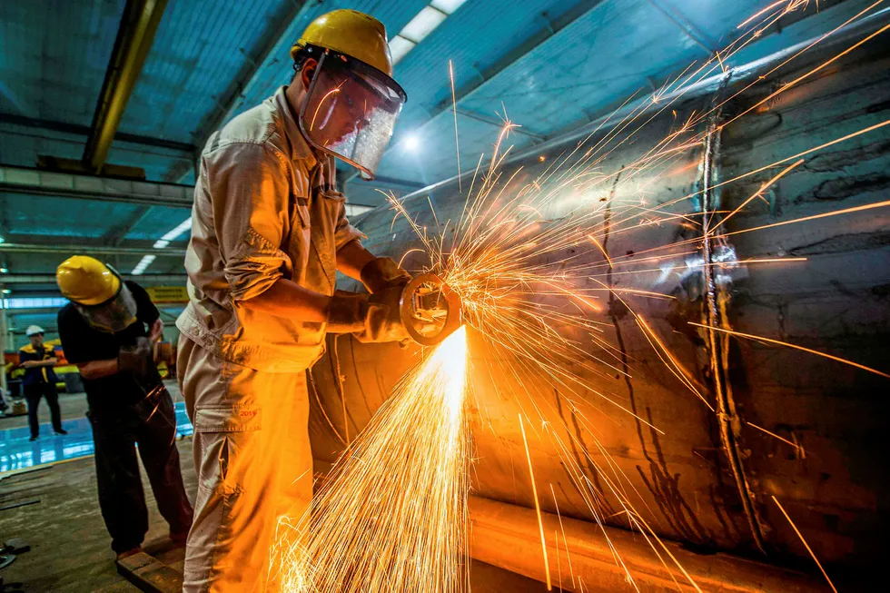 Firing up: a worker welds medal truck parts at a factory in Weifang in China's Shandong province last week