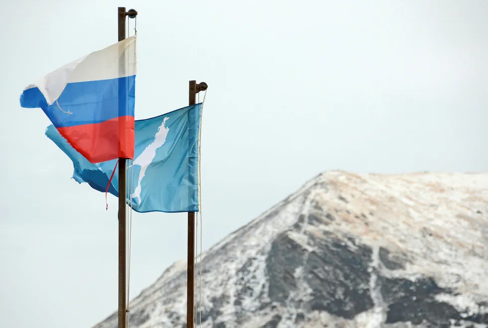 A national flag of Russia and a flag of Russia's Sakhalin region flutter in the village of Malokurilskoye on the island of Shikotan, Southern Kuriles, Russia