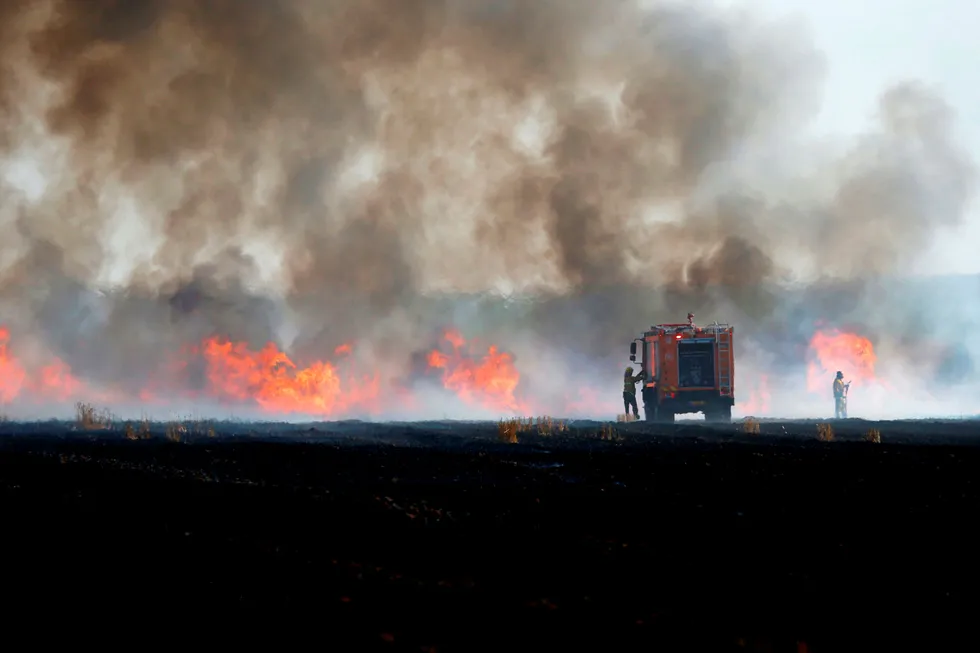 Israelske tropper prøver å stoppe branner langs grensen til Gazastripen. Brannene ble startet i forbindelse med palestinske demonstrasjoner. Foto: Ahmad Gharabli/AFP/NTB Scanpix