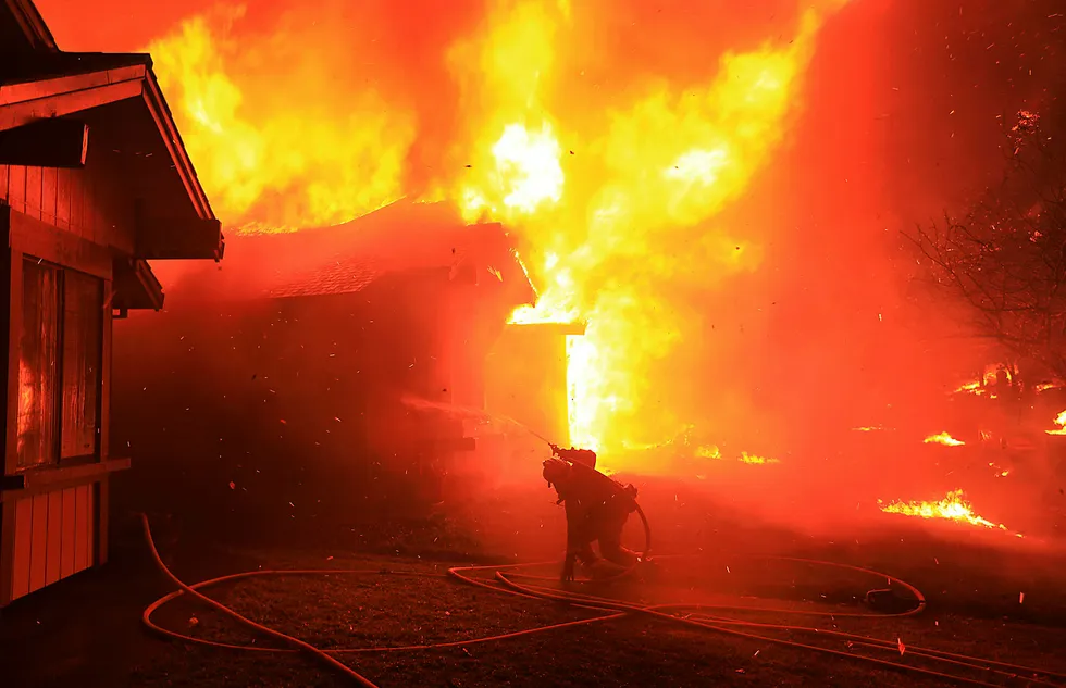 Skogbrannen i California had ødelagt over 1500 hjem og bedrifter. På bildet forsøker en brannmann å hindre at et hjem i Coffey Park i Santa Rosa å brenne ned mandag. Foto: Kent Porter/The Press Democrat via AP/NTB scanpix