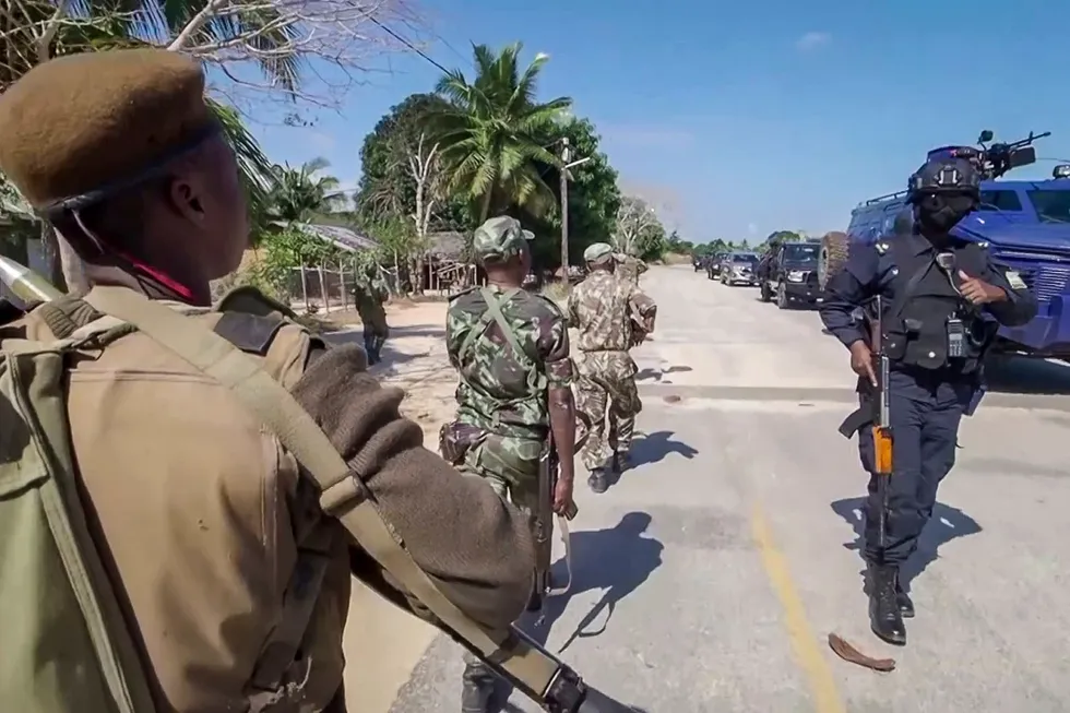 On patrol: In this image made from video, a Rwandan policeman, right, and Mozambican military, left, patrol near the Amarula Palma hotel in Palma, Cabo Delgado, Mozambique