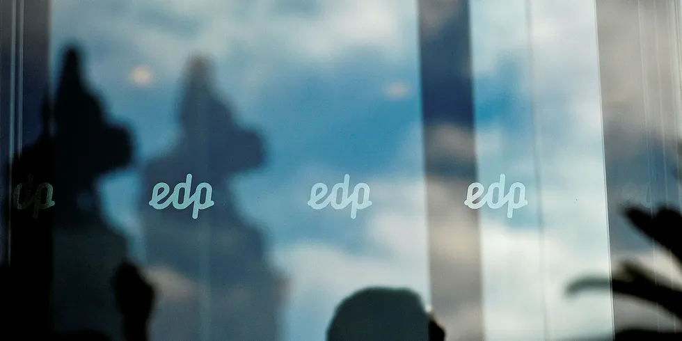 A man's reflection is seen under the EDP (Electricidade De Portugal) logo at the EDP headquarters in Marques do Pombal, Lisbon.