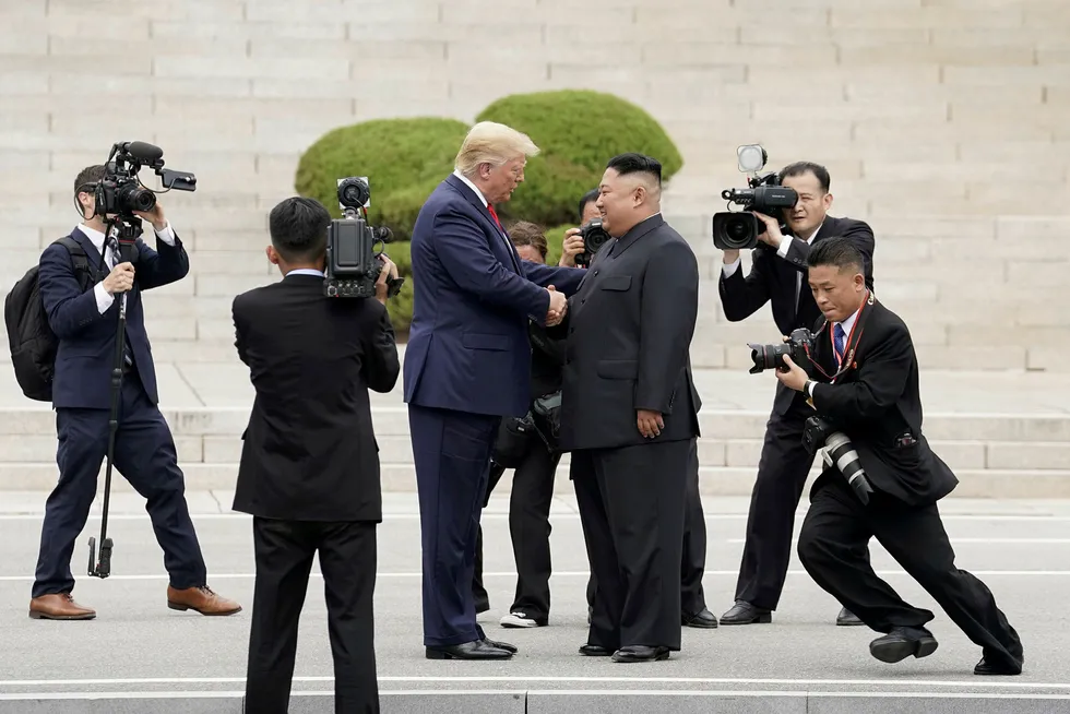Dette bildet ble tatt for knapt et år siden på grensen mellom Nord- og Sør-Korea. Nå gir Kim Jong-un (til høyre) beskjed til Donald Trump om å holde seg unna.
