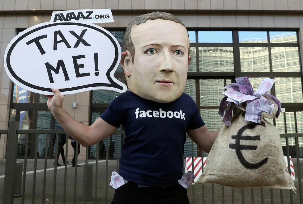 An activist wearing a mask depicting Facebook's CEO Mark Zuckerberg demonstrates during the European Union finance ministers meeting, outside the EU headquarters in Brussels, Belgium, December 4, 2018. REUTERS/Yves Herman TPX IMAGES OF THE DAY ---