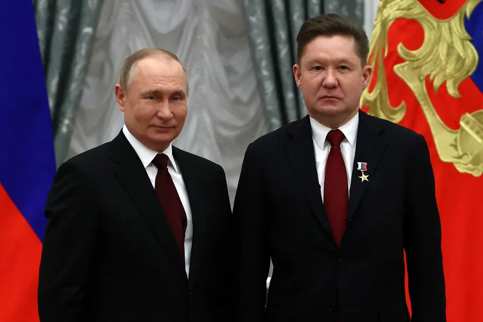 Boss support: Russian President Vladimir Putin (L) poses next to Gazprom executive board chairman Alexei Miller after giving the Hero of Labor of Russia award in the Kremlin in Moscow on 2 February 2022