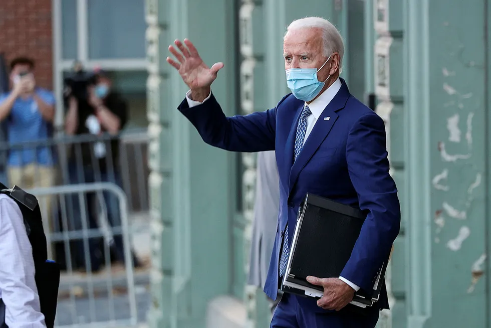 U.S. President-elect Joe Biden carries folders as he departs following briefings.