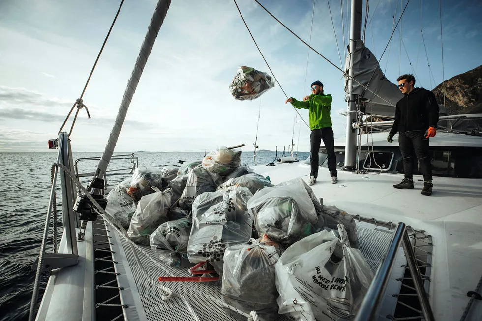 De to frivillige Frederick Anthony Bernet og Asgeir Johansen tar søppel fra fjæra om bord i seilbåten til Pukka Travel.