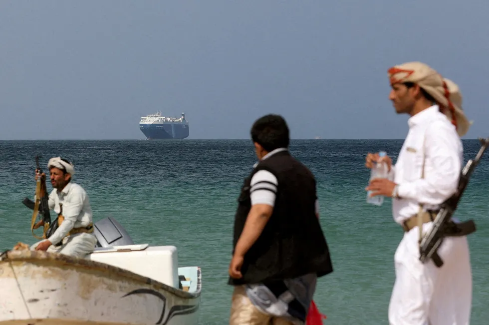 Armed men stand on the beach in this file photo as the Galaxy Leader commercial ship, seized by Yemen's Houthis last month, is anchored off the coast of al-Salif, Yemen, December 5, 2023.