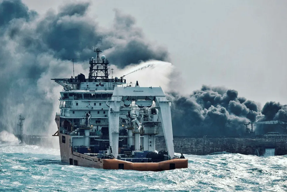 En kinesisk brannslukkingsbåt forsøker å slukke brannen i oljetankeren Sanchi. Skipet har nå stått i brann i seks dager etter at det kolliderte med et kinesisk lasteskip lørdag forrige uke. Foto: AP / NTB scanpix