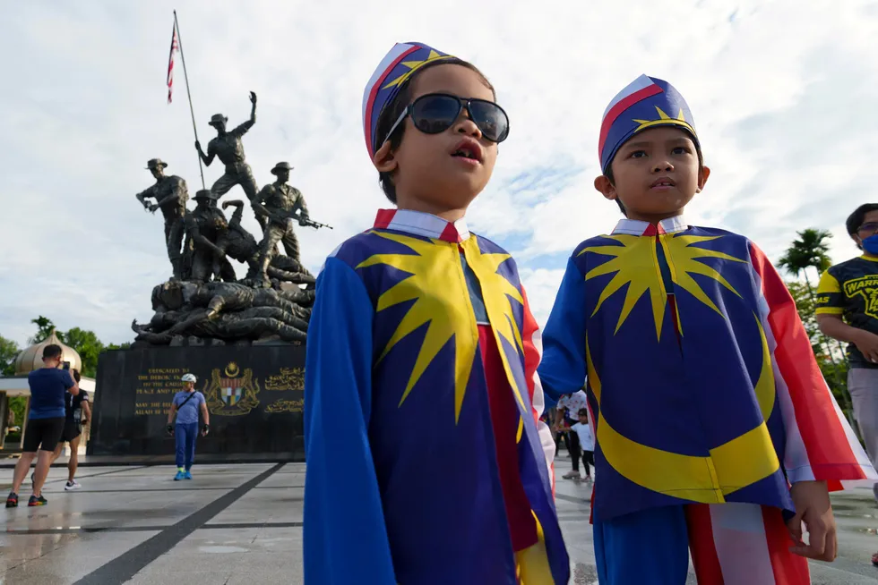 Celebrations: two Malay boys wearing Malaysian national flag costumes in front of the National Monument in Kuala Lumpur during the country's National Day celebrations this week