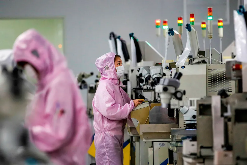 Kinesiske fabrikker forsøker å komme i gang med produksjonen. Det kan bli store forsinkelser i produksjonen. Ansatte er redde for å reise på jobb. Her fra en databrikkefabrikk i Jiangsu-provinsen, hvor arbeidere forsøker å unngå smitte.