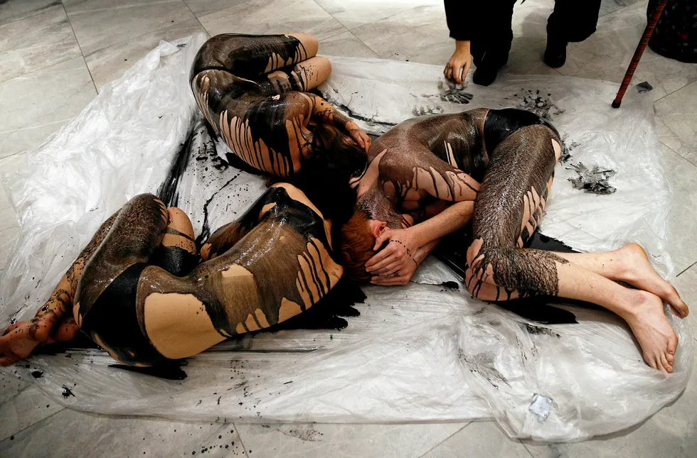 Oil on canvas: Extinction Rebellion members lie on the ground, covered in fake oil, to protest against an exhibition sponsored by BP at London's National Portrait Gallery