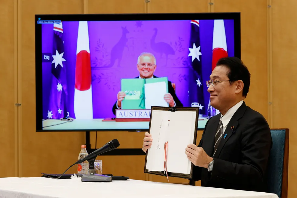 Cooperation: Japan’s Prime Minister Fumio Kishida (right) and Australia’s Prime Minister Scott Morrison, seen on screen, show off signed documents during a virtual summit to sign the Reciprocal Access Agreement