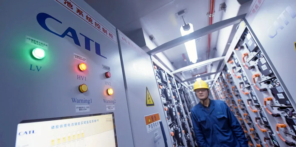 A staff member of a power supply company checks the operation of an energy storage device produced by Ningde Times in a mobile storage tank in Hangzhou, Zhejiang province, China.