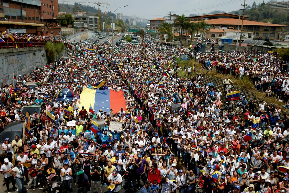 Venezuela innfører en rekke tiltak som følge av alle strømbruddene. På bildet hører tilhengerne av opposisjonsleder og selvutnevnt president Juan Guaidó ham tale lørdag i San Antonio.