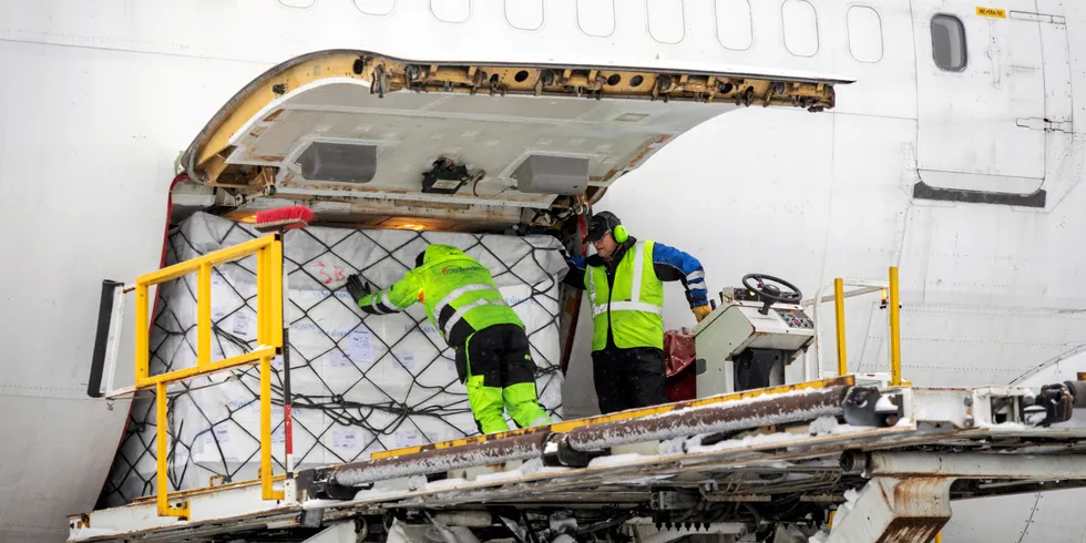 Yngve Ramberg Skaug gir den siste av 14 paller med norsk laks et siste dytt inn i jumbojeten som skal fly til Kina med en mellomlanding i Kasakhstan for etterfylling av drivstoff. Turen til Kasakhstan tar rundt 4,5 timer, mens neste legg tar 5. Vernon C.H. Thor (t.h.) styrer liften.