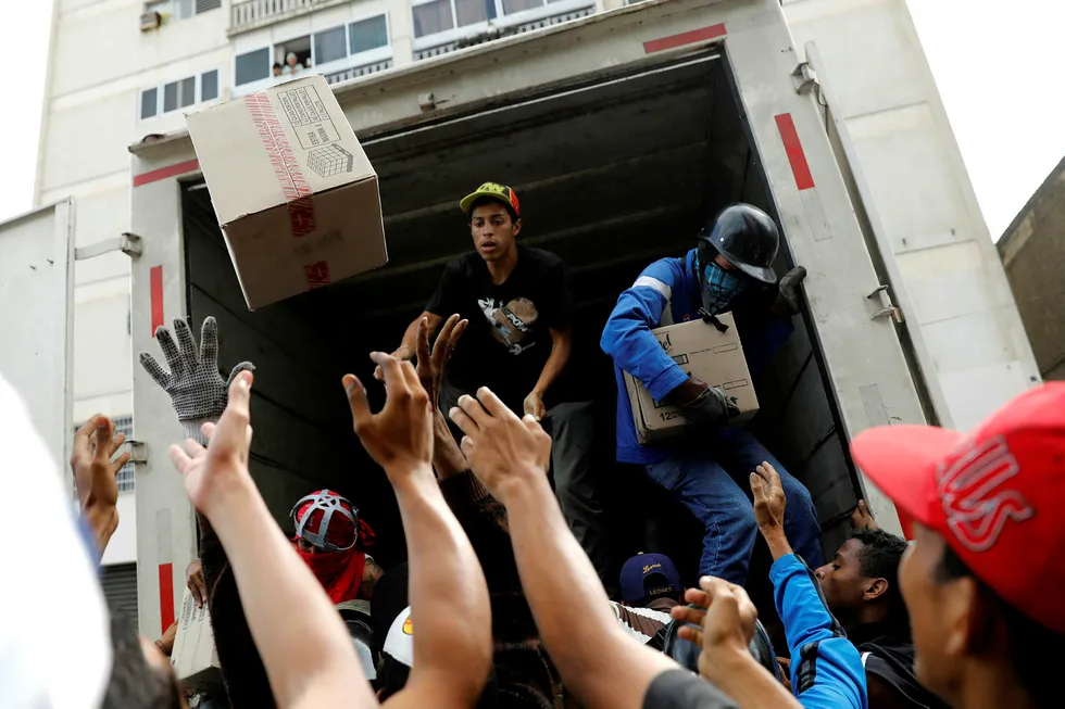 Demonstranter plyndrer en lastebil under en demonstrasjon mot president Nicolas Maduro i Caracas, Venezuela, i slutten av mai i år. Foto: Carlos Garcia Rawlins/Reuters/NTB scanpix