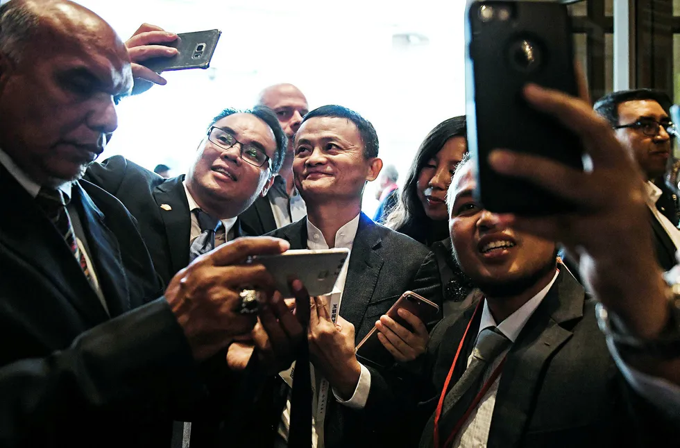 Alibaba-grunnlegger Jack Ma (i midten) må konstatere at «lillebror» har passert hans selskap i børsverdi. Foto: Mohd Rasfan/AFP/NTB Scanpix