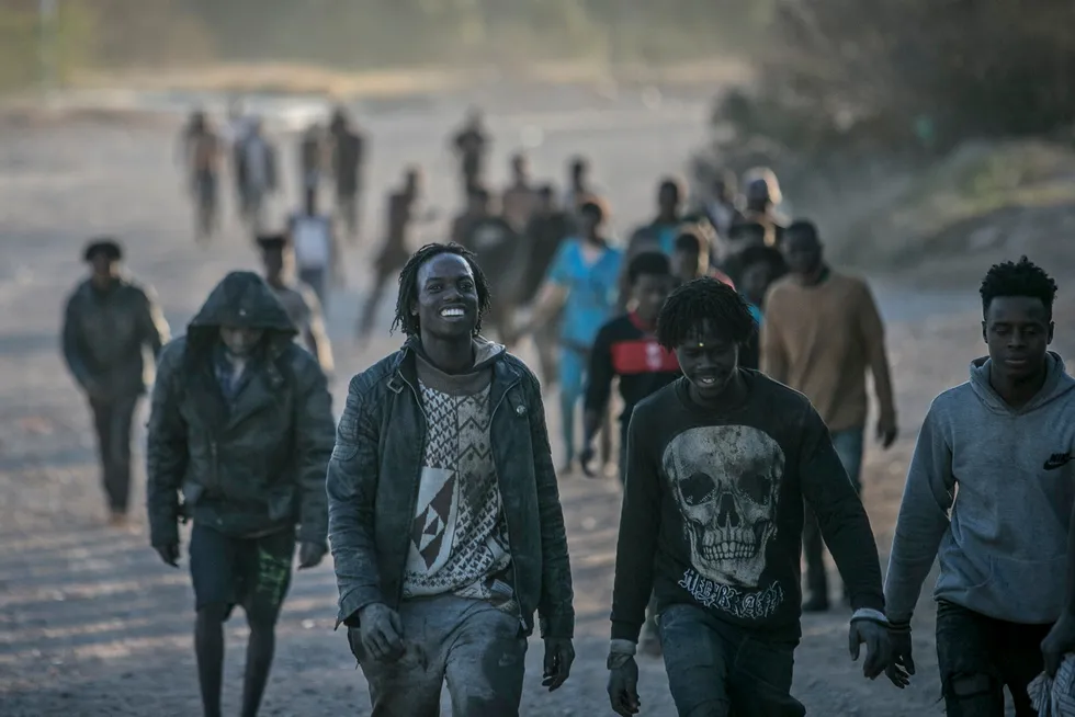 Migranter ankommer spansk jord 3. mars etter å ha klatret over gjerdene som skiller den spanske enklaven Melilla fra Marokko.