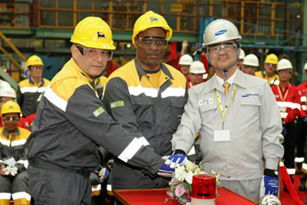 Milestone: Mozambique's Mineral & Energy Resources Minister Ernesto Max Tonela (centre) pushes plasma-cutting button to start steel-cutting at Samsung. He is flanked by Eni's Stefano Maione (left) and Samsung chief executive JO Nam.