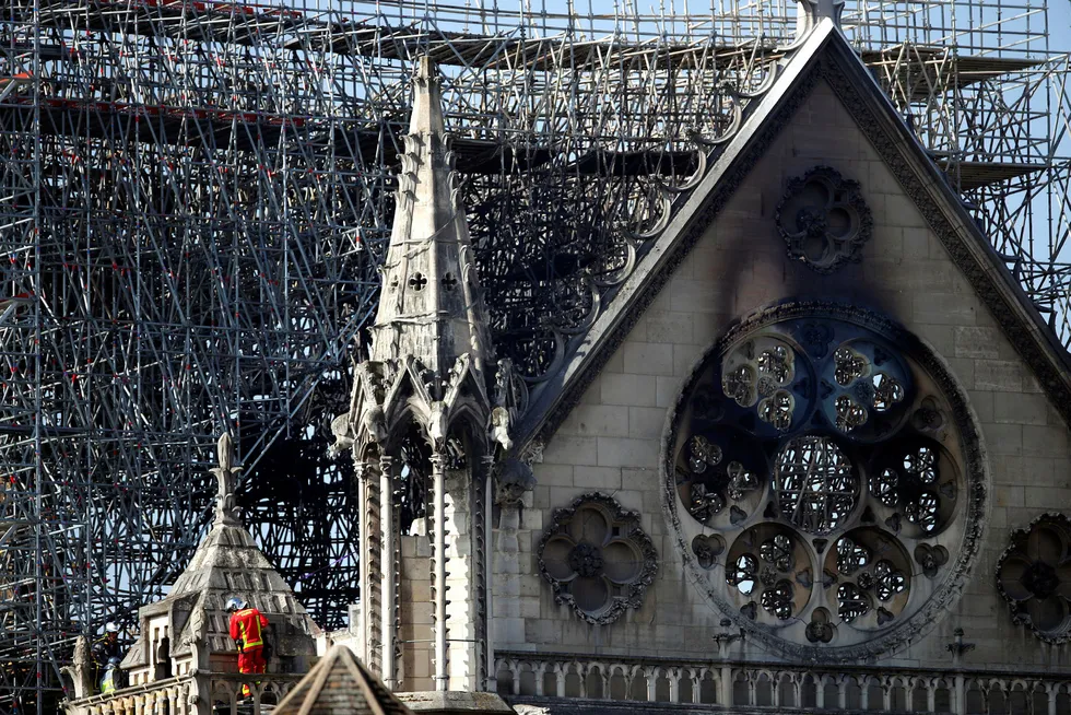 En brannmann beveger seg opp på en balkong i Notre-Dame onsdag, to dager etter den ødeleggende brannen i katedralen. Foto: AP / NTB scanpix