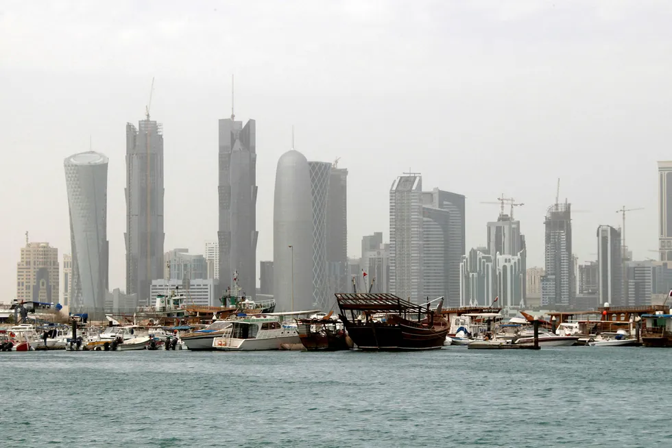 En tradisjonell fiskebåt av tre, Dhow, sees i havnen med skyskraperne i Qatars hovedstad Doha i bakgrunnen. Foto: Jacky Naegelen/Reuters/NTB scanpix