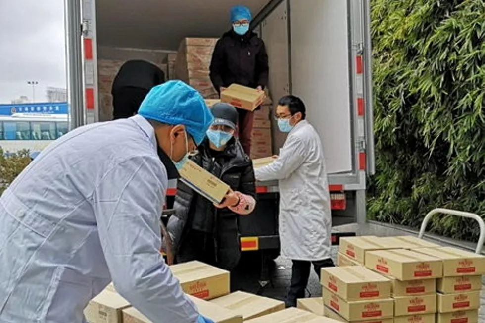 Employees from Thai Union China unload King Oscar products at a local hospital during the COVID-19 pandemic.