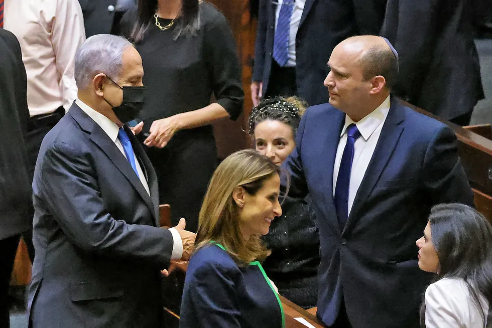 Israels avtroppende statsminister Benjamin Netanyahu tar den påtroppende statsministeren Naftali Bennett i hånden etter at voteringen i nasjonalforsamlingen Knesset søndag gjorde det klart at det blir regjeringsskifte.