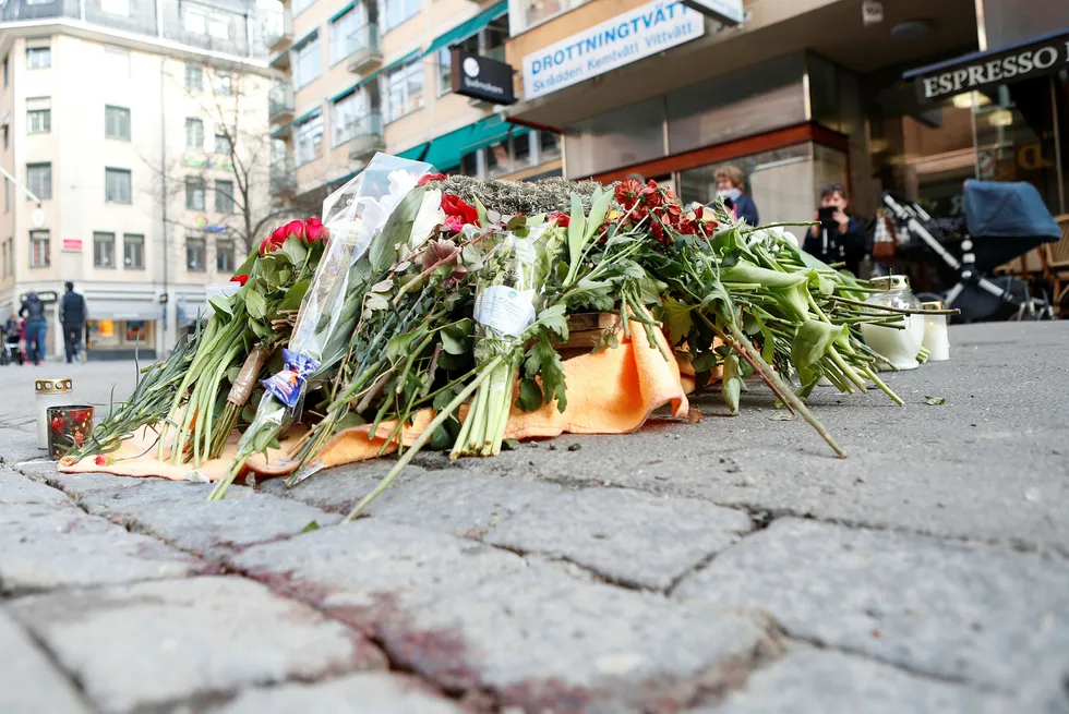 Det har blitt lagt ned blomster der en person ble drept i Drottninggatan fredag da en lastebil kjørte nedover gaten før den traff Åhlens. Foto: Torstein Bøe/NTB Scanpix