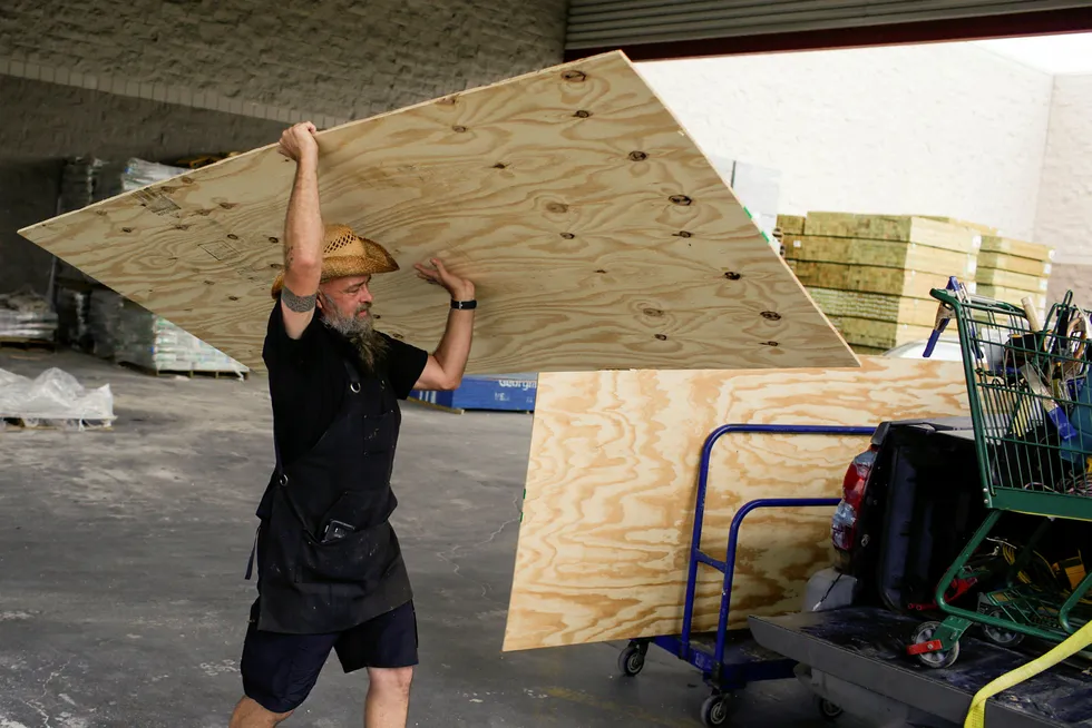 Battening down: a New Orleans resident loads plywood into his truck in preparation for arrival of storms Marco and Laura