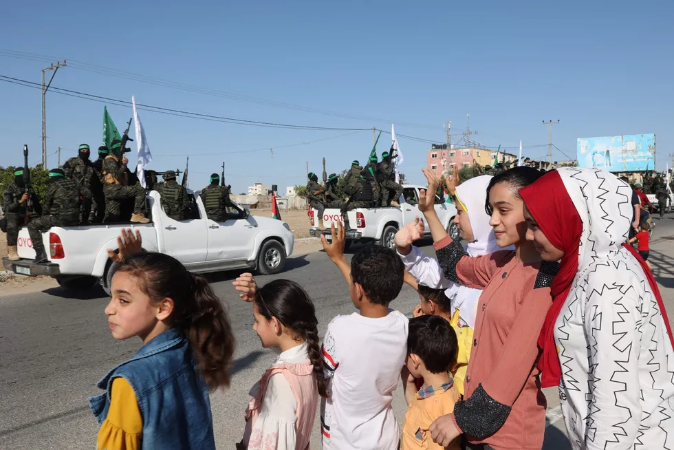 Palestinere i Gaza vinker til den væpnede delen av Hamas, Al-Qassam brigadene, under en militærparade i byen Khan Yunis torsdag.