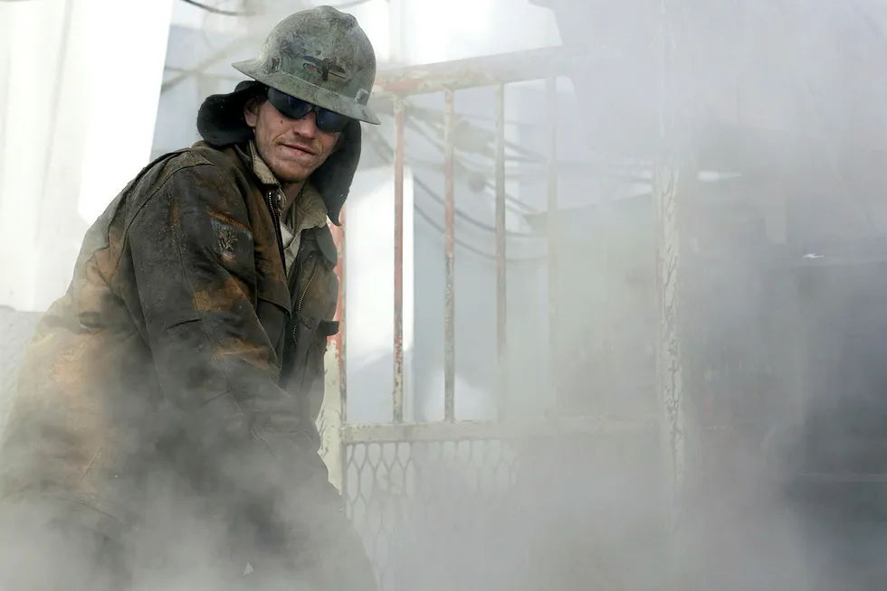Building up steam: a worker de-ices the floor of a shale gas drilling rig
