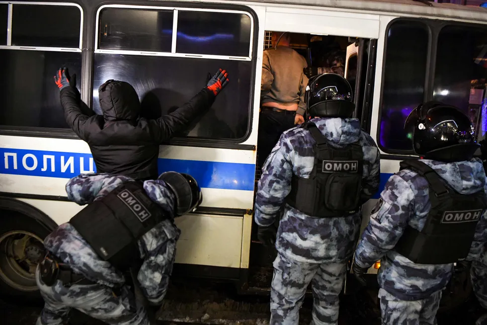 Suppression: Russian riot police search street protesters and push them into a bus during an evening rally in Moscow on 2 February 2021