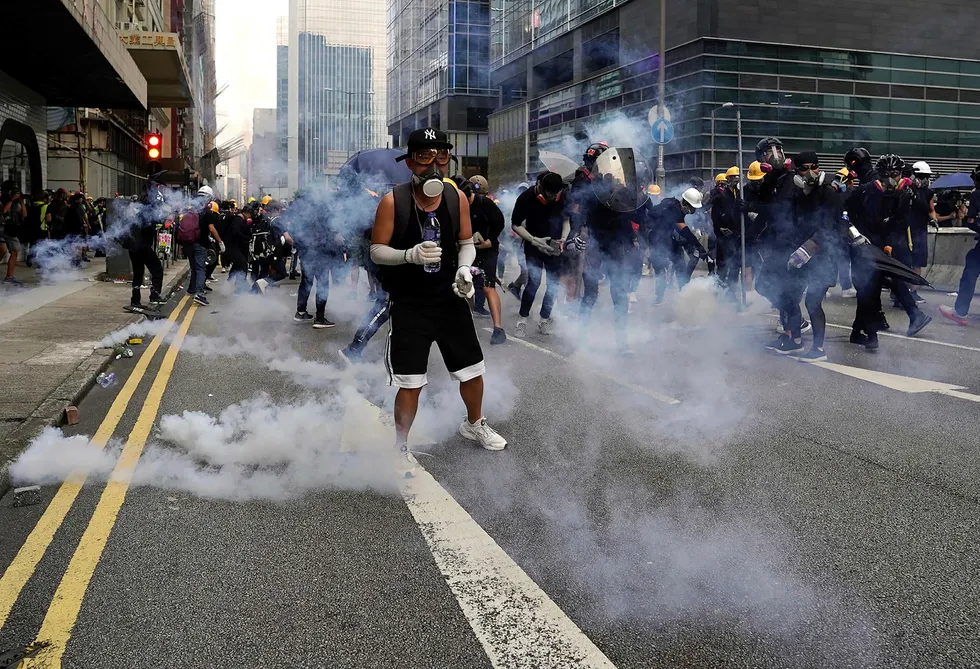 Flere hundre svartkledde demonstranter støtte lørdag sammen med opprørspoliti i Hongkong. Demonstrantene kastet brannbomber, stein og vannflasker mot politiet, som svarte med tåregass og køller.