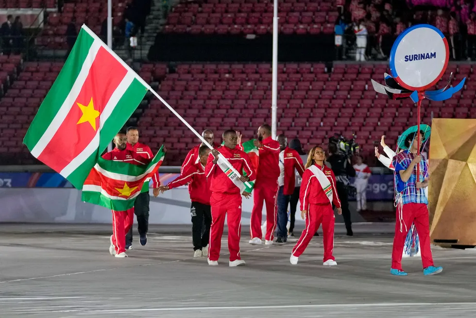 Jair Tjon and Tachana Dalger of Suriname carry their country's flag during the opening ceremony of the Pan American Games in October 2023.