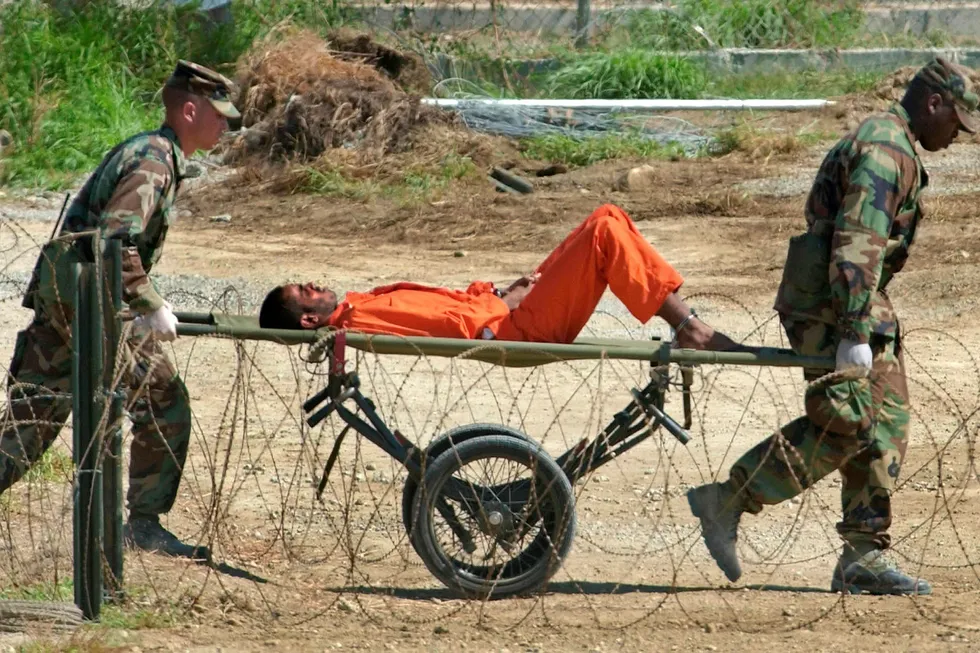 Tortur virker mot sin hensikt, slår artikkelforfatterne fast. På dette bildet fra 2002 blir en fange fra Afghanistan fraktet til avhør i Camp X-Ray i Guantánamo fangeleir. Foto: Lynne Sladky/AP/NTB Scanpix
