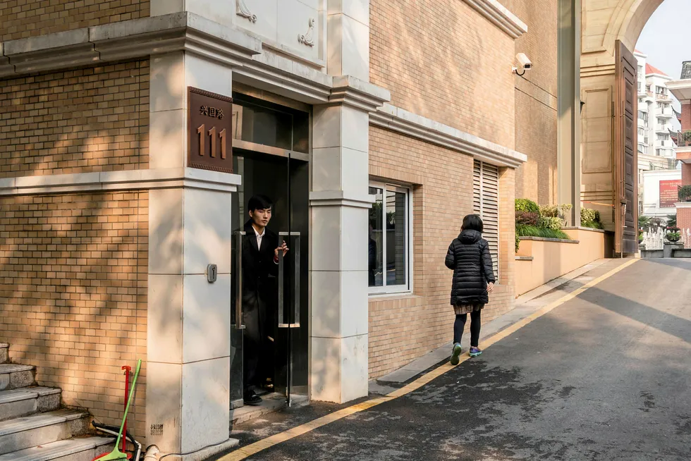 Low profile: a security guard stands at the entrance to an unmarked building compound listed as an address for CEFC China Energy in Shanghai