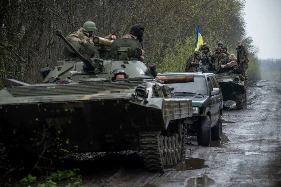 Ukrainske tjenestemenn sitter på toppen av en pansret kampvogn mens Russlands angrep på Ukraina fortsetter, på et ukjent sted i Øst-Ukraina. Bildet utgitt 19. april 2022.