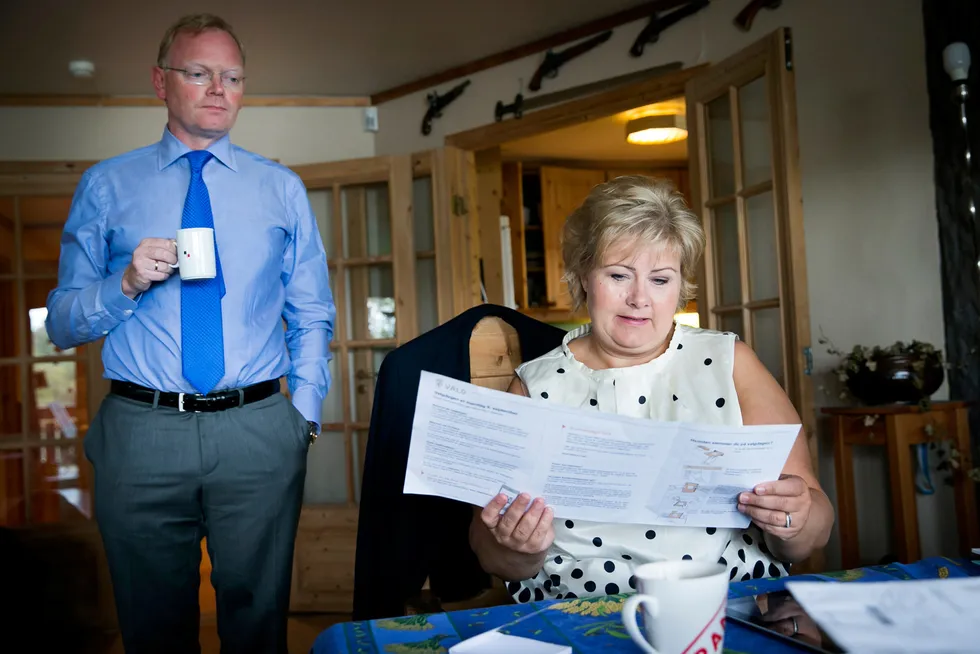 Høyre-leder Erna Solberg leser en valgbrosjyre en rolig morgen hjemme i huset i Bergen før valgdagen i 2013. Bak står ektemannen Sindre Finnes.