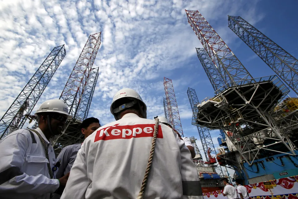On site: Keppel workers stand among jack-up rigs in Singapore