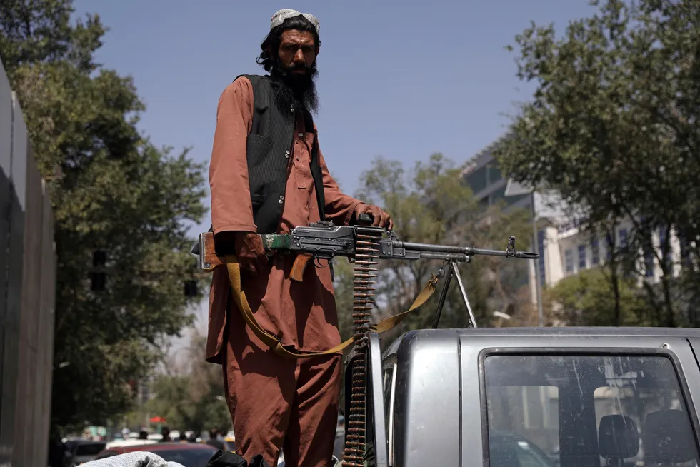A Taliban fighter sits on the back of vehicle with a machine gun in front of the main gate leading to the Afghan presidential palace, in Kabul. In the past, when countries have tumbled into chaos and conflict, wealthier people have either relied on paper money or precious metals to store their wealth. Now crypto is creeping in.